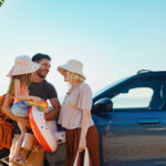 Happy Family Preparing for a Summer Vacation on a Beachside Road