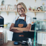 Portrait of a smiling mature female barista behind the counter